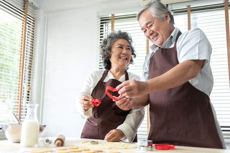 two seniors with aprons and baking