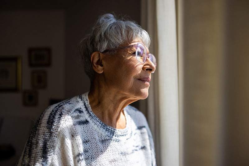 older woman looking out the window