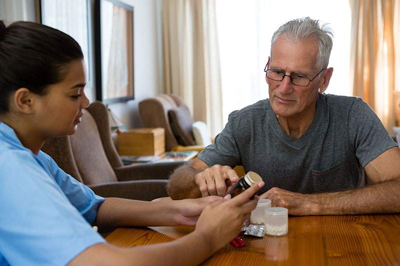 healthcare aid going over medication with patient