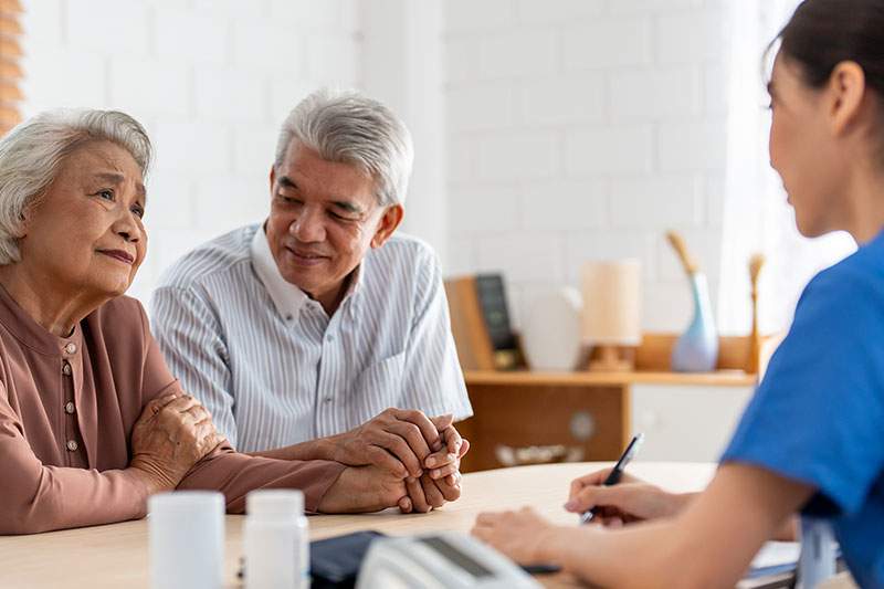 nurse speaking with an elderly couple